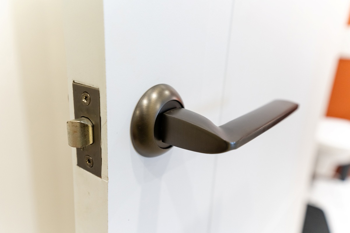 close up of a door handle on white door