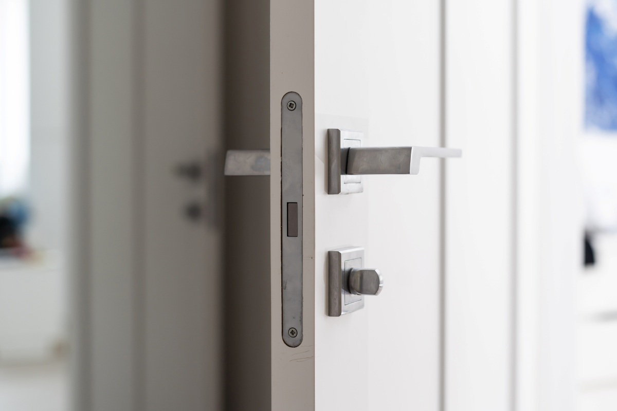Modern white door with matte black handle and magnetic locks, lock with insert key