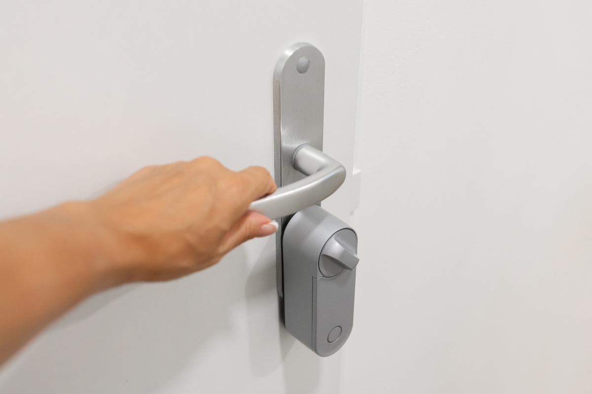 Female hand touching smart door handle with electronic lock system